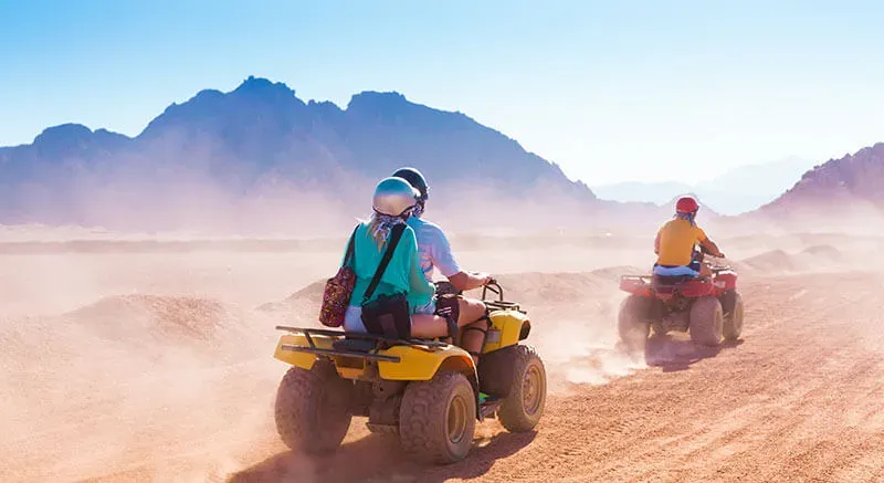 Marsa Alam Desert Safari adventure driving quad bikes through golden sand dunes.